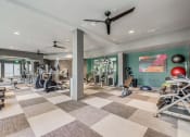Thumbnail 4 of 12 - Gym with weights and cardio machines and a ceiling fan at The Atlantic Highland Park, Dallas, Texas