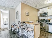 Thumbnail 2 of 19 - Kitchen with a bar and three stools in front of a counter top at The Atlantic Ashford, Atlanta, Georgia, 30319