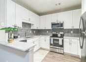 Thumbnail 8 of 15 - Kitchen with white cabinets at The Atlantic North Highland, Charlotte