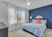 Thumbnail 13 of 23 - A bedroom with a bed, nightstand, and window with blinds at Boca Colony Apartments, Boca Raton, FL, 33433