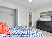 Thumbnail 11 of 23 - A bedroom with a blue and white patterned bedspread at Boca Colony Apartments, Florida