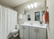 Thumbnail 8 of 18 - a bathroom with a shower and a sink and a toilet at Magnolia Terrace Apartments, Charlotte