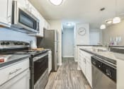 Thumbnail 3 of 18 - an open kitchen with stainless steel appliances and white cabinets at Magnolia Terrace Apartments, North Carolina