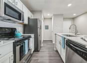 Thumbnail 11 of 18 - an empty kitchen with white cabinets and stainless steel appliances at Magnolia Terrace Apartments, North Carolina 28213