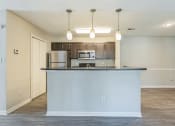Thumbnail 10 of 18 - A kitchen with a white counter and brown cabinets at Magnolia Terrace Apartments, Charlotte, NC