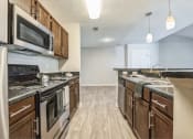 Thumbnail 9 of 18 - an open kitchen with stainless steel appliances and wooden cabinets at Magnolia Terrace Apartments, Charlotte, NC, 28213