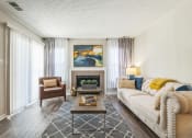 Thumbnail 5 of 18 - A living room with a fireplace and a painting on the wall at Magnolia Terrace Apartments, North Carolina