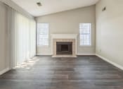 Thumbnail 13 of 18 - an empty living room with a fireplace and windows at Magnolia Terrace Apartments, Charlotte, 28213