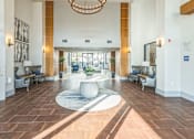 Thumbnail 3 of 34 - A large, well-lit lobby with a circular rug and a chandelier  at The Atlantic Memorial, Houston