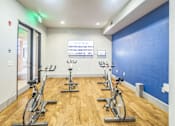 Thumbnail 24 of 34 - A gym with a row of stationary bikes and a sign on the wall  at The Atlantic Memorial, Houston