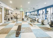 Thumbnail 22 of 34 - a fitness room with cardio machines and weights at the apartments