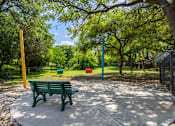 Thumbnail 4 of 34 - A park with a green bench and trees at Reserve at Canyon Creek, San Antonio, 78230