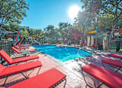 Thumbnail 8 of 34 - A sunny day at the pool with red sun loungers at Reserve at Canyon Creek, San Antonio,78230