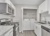 Thumbnail 2 of 16 - Kitchen with white appliances and granite counter tops at The Atlantic Briarcliff, Atlanta, GA