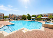 Thumbnail 7 of 14 - A sunny day at the pool with apartment buildings in the background.