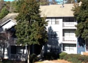 Thumbnail 4 of 14 - the apartment building is shown with a large tree in front of it at The Atlantic Vinings, Smyrna, GA, 30080