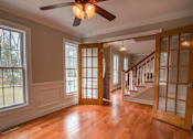 Thumbnail 4 of 17 - a empty living room with a wood floor and a ceiling fan