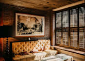 Thumbnail 8 of 17 - A room with a tufted sofa and a framed picture on the wall.