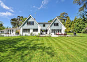 Thumbnail 14 of 17 - A large house with a green lawn in front.