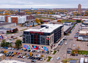 Thumbnail 7 of 17 - an aerial view of a city with a building and parking lot