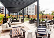 Thumbnail 18 of 43 - a rooftop patio with couches and tables and chairs