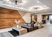 Thumbnail 1 of 43 - a living room with a wooden accent wall and two modern lights