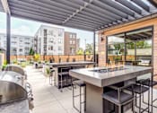 Thumbnail 15 of 43 - an outdoor patio with tables and chairs and a grill