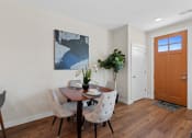 Thumbnail 27 of 30 - a dining room with a table and chairs and a wooden door at Tivoli Green Apartments & Townhomes, Mount Pleasant, WI