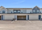 Thumbnail 6 of 30 - the front of a blue and white house with a garage door at Tivoli Green Apartments & Townhomes, Mount Pleasant, WI