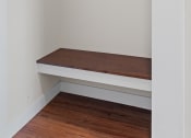 Thumbnail 30 of 30 - a small room with a wooden bench and a white wall at Tivoli Green Apartments & Townhomes, Mount Pleasant, WI
