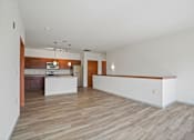 Thumbnail 15 of 30 - A large empty room with wooden floors and white walls.