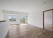 Thumbnail 14 of 30 - A room with wooden flooring and a large mirror on the wall.