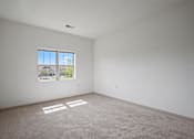 Thumbnail 16 of 30 - A room with a large window and a carpeted floor.