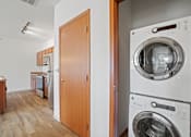 Thumbnail 19 of 30 - A washing machine is on top of a dryer in a small apartment.