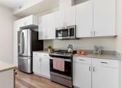 Thumbnail 3 of 12 - kitchen view with fridge, stove, and microwave