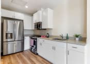 Thumbnail 2 of 12 - kitchen view with stove, microwave, fridge, and sink