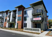 Thumbnail 1 of 30 - exterior photo of monument sign labeled "100 Avram Ave Bella Creek" in front of exterior of newly constructed apartment building