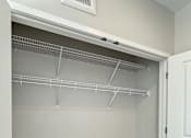 Thumbnail 22 of 31 - A white closet with a white door and shelves.