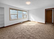 Thumbnail 20 of 27 - A room with a carpeted floor, a window, and a door.