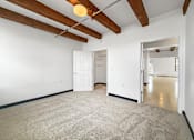 Thumbnail 28 of 34 - A room with a white door and a carpeted floor.