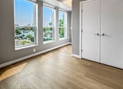 Thumbnail 10 of 22 - A room with a white door and a window overlooking a cityscape.