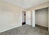 Thumbnail 10 of 15 - A room with a carpeted floor and a white door.