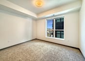 Thumbnail 5 of 21 - A room with a window and carpeted floor.