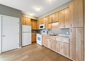 Thumbnail 8 of 22 - A kitchen with wooden cabinets and white appliances.