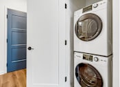 Thumbnail 6 of 37 - A white cabinet with two washing machines stacked on top of each other.