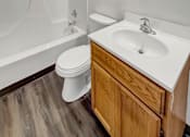 Thumbnail 10 of 28 - A white toilet sits next to a white sink in a bathroom.