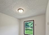 Thumbnail 5 of 28 - A room with a window showing a green lawn outside.