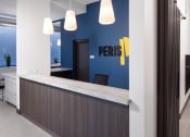 Thumbnail 20 of 37 - a reception area with a blue wall and a counter with a desk and chairs