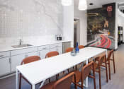 Thumbnail 34 of 37 - a long white table and chairs in a room with white cabinets and a wall mural