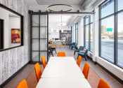 Thumbnail 35 of 37 - a long table with orange chairs in a room with large windows